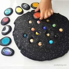 a child touching the planets on top of a play mat with rocks and magnets