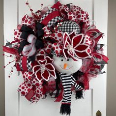 a red and black wreath with a snowman on it