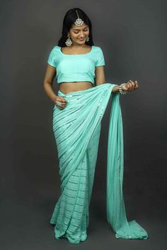 Glam up your persona with this all-new Turquoise Georgette pre- pleated saree with delicate work of silver sequins. It becomes a perfect outfit for weddings and festive occasions. It is styled with a shimmering white blouse.Product Features: Saree Type: Ready to wear, Pre-stitched, Pre-draped Saree Saree Color: Turquoise Blouse Color: Turquoise Saree Fabric: Georgette Blouse Fabric: Georgette Work: Sequins Shoulder Drape: Customer must select the shoulder drape style while ordering Occasion: Par Festive Turquoise Pre-draped Saree, Turquoise Lehenga With Dupatta For Party, Party Lehenga With Dupatta In Turquoise, Designer Turquoise Saree Sets, Bollywood Style Pre-draped Saree In Light Blue, Elegant Turquoise Saree For Diwali, Festive Light Blue Blouse Piece For Party, Bollywood Style Turquoise Sets For Reception, Turquoise Bollywood Sets For Reception