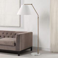 a living room scene with focus on the couch and floor lamp in the foreground