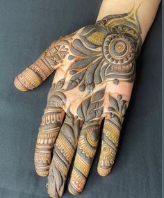 a person's hand with hennap and intricate designs on the top of it