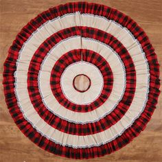 a red and black checkered rug on a wooden floor with a white circle in the center