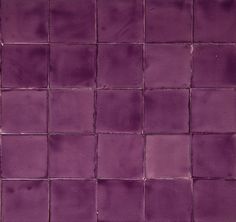 a purple tiled wall with small squares on it