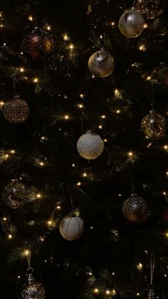 a christmas tree with many ornaments hanging from it's sides and lights on the branches