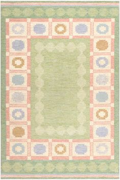 an area rug with squares and flowers on the center, in pastel green and pink colors