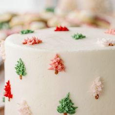 a white cake with red and green decorations on it's icing is sitting on a plate