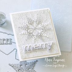 a snowflaked card with the word merry written in white and surrounded by christmas decorations