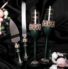 three wine glasses with gold and silver glitter on them, sitting next to a knife