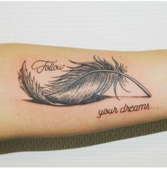 a woman's arm with a feather and the words follow your dreams on it