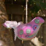 a pink bird ornament hanging from a tree