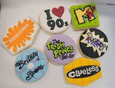 six decorated cookies in the shape of different logos and words are displayed on a white surface