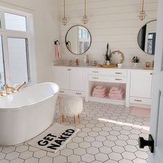 a bath room with a tub a mirror and a rug on the floor in front of it