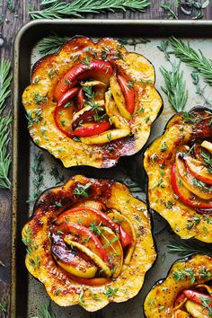 four squash dishes on a baking sheet with fresh herbs