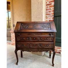 an old wooden desk sitting in front of a brick building