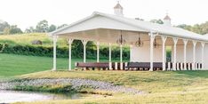 a white gazebo sitting on top of a lush green field