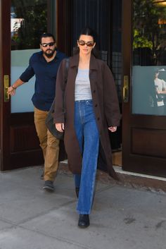 a man and woman walking out of a building