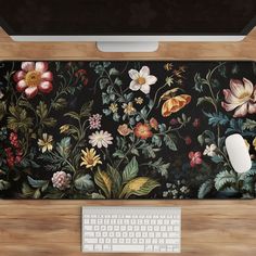 a computer keyboard and mouse on a desk with a floral wallpaper design in the background