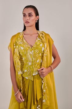 Yellow asymmetric cape with sequin embroidered floral patterns on border. Comes with sequin embroidered jacket and draped skirt. - Aza Fashions Elegant Fitted Jacket Dress For Festive Occasions, Elegant Designer Cape Set, Designer Fitted Pre-draped Saree For Wedding, Elegant Fitted Pre-draped Saree With Cape Sleeves, Elegant Cape Sets For Reception, Designer Traditional Drape Sets For Parties, Designer Wear Fitted Pre-draped Saree, Elegant Cape Style Lehenga For Party, Designer Fitted Pre-draped Saree For Designer Wear