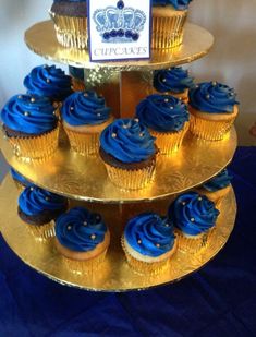 three tiered cake stand with blue cupcakes on it