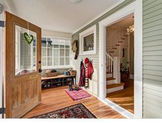 an entry way with wooden floors and white trim on the walls, two doors open to reveal another room