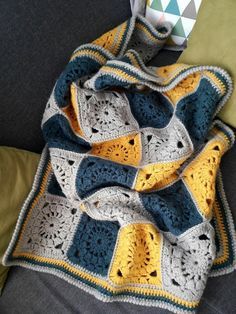 a crocheted blanket sitting on top of a couch