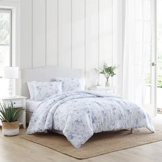 a white bed with blue flowers on it