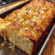 a close up of a pan of food with cheese and bread toppings on it