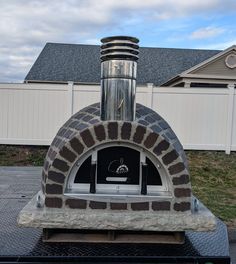 an outdoor pizza oven sitting on top of a table