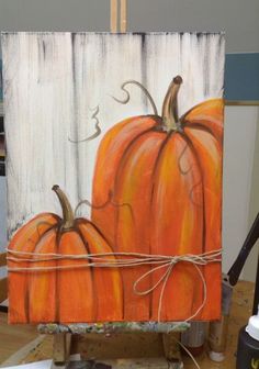 a painting of two pumpkins tied to a wooden board