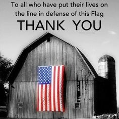 an american flag hanging on the side of a barn with a thank you message below