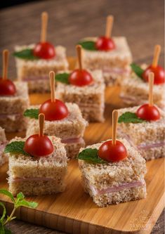 small sandwiches with cherry tomatoes and toothpicks on a cutting board, ready to be eaten