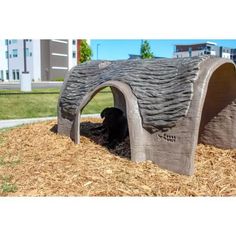 there is a dog house made out of wood chips