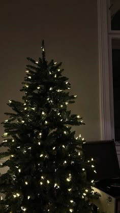 a small christmas tree is lit up in the dark