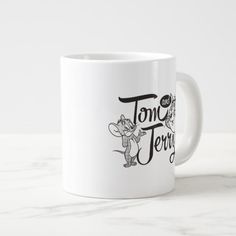 a white coffee mug with the words tom and jerry on it