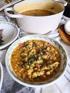 a white bowl filled with soup on top of a table next to other bowls and spoons