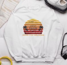 Elevate your casual wardrobe with our "Never Stop Exploring" sweatshirt. Designed for adventurers and dreamers alike, this sweatshirt is perfect for those who believe in pushing boundaries and seeking new horizons. - Made with a medium-heavy fabric blend of 50% cotton and 50% polyester (8.0 oz/yd² (271.25 g/m this sweatshirt feels cozy and is the perfect choice for those colder months. - The classic fit along with the crew neckline deliver a comfy wearing experience with a clean-cut style. Meanwhile, the double-needle stitching at the shoulder, armhole, neck, waistband, and cuff seams add top-tier durability.  - Say goodbye to itchiness thanks to the gray, pearlized tear-away label.  .: Made using 100% ethically grown US cotton. Gildan is also a proud member of the US Cotton Trust Protocol White Crew Neck Sweatshirt For Outdoor Activities, White Graphic Print Sweatshirt For Outdoor Activities, Casual Crew Neck Sweatshirt For Adventure, White Relaxed Fit Sweatshirt For Outdoor Activities, White Graphic Print Sweatshirt For Outdoor, White Long Sleeve Adventure T-shirt, White Long Sleeve T-shirt For Adventure, Sporty Long Sleeve Sweatshirt For Adventure, White Long Sleeve Sweatshirt For Adventure