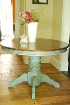 a vase with flowers on top of a wooden table