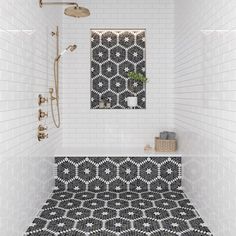 a bathroom with black and white tiles on the floor, shower head, and mirror