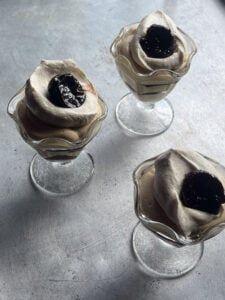 three small glass vases with black flowers in them