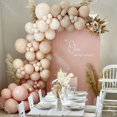 a table set up with balloons and flowers