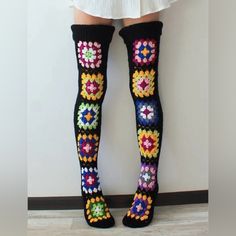 the legs of a woman wearing colorful crocheted socks and knee - high socks