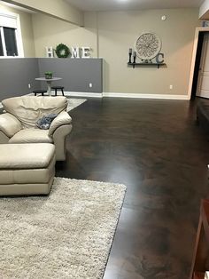 a living room with hard wood flooring and white couches in it's center