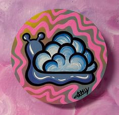 a round painting with blue and pink clouds on it