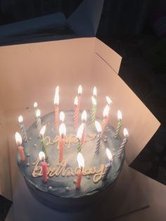 a birthday cake with lit candles on it