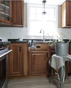 a kitchen with wooden cabinets and an old fashioned potted plant on the counter top