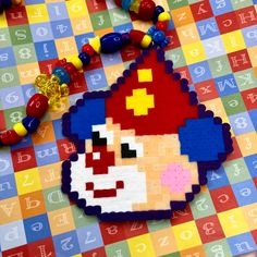 a necklace made out of legos and beads on top of a colorful tablecloth