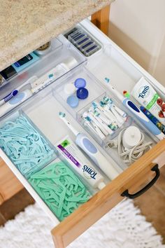 an open drawer with various items in it, including toothbrushes and other hygiene products