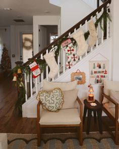 christmas stockings hung on the banister above two chairs