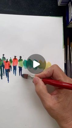 a person is holding a paintbrush and drawing people on paper with colored pencils