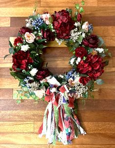 a wreath with red and white flowers on a wooden floor